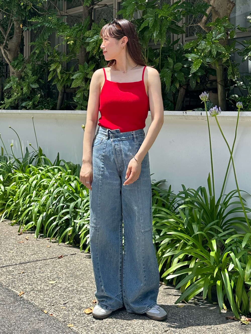 レッド系のキャミソール、ブルー系のデニムパンツを着用したレディースの夏コーディネートの2枚目の写真