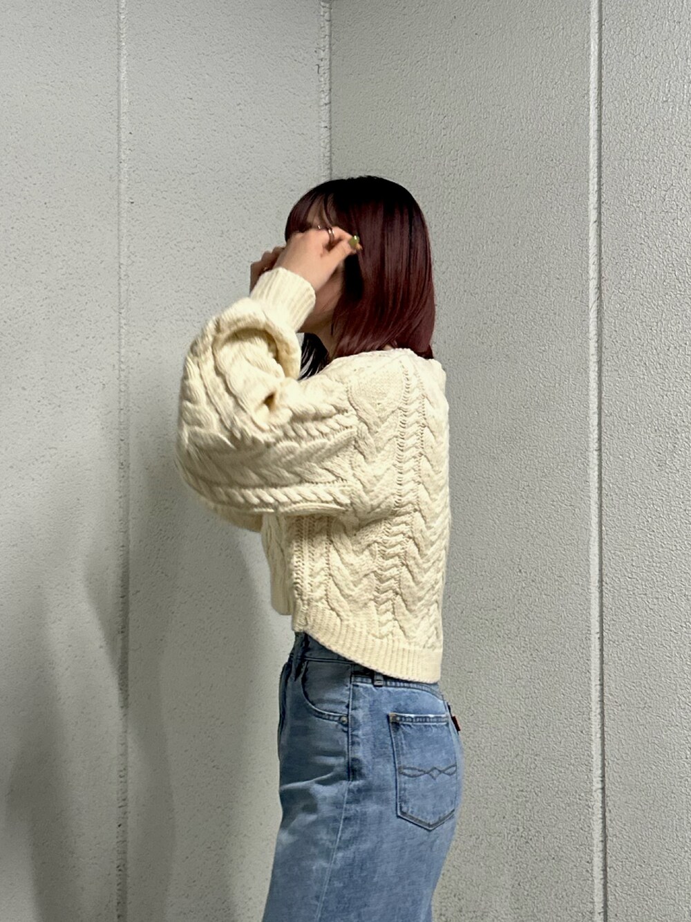 ホワイト系のニット/セーター、ブルー系のデニムパンツを着用したレディースの冬コーディネートの4枚目の写真