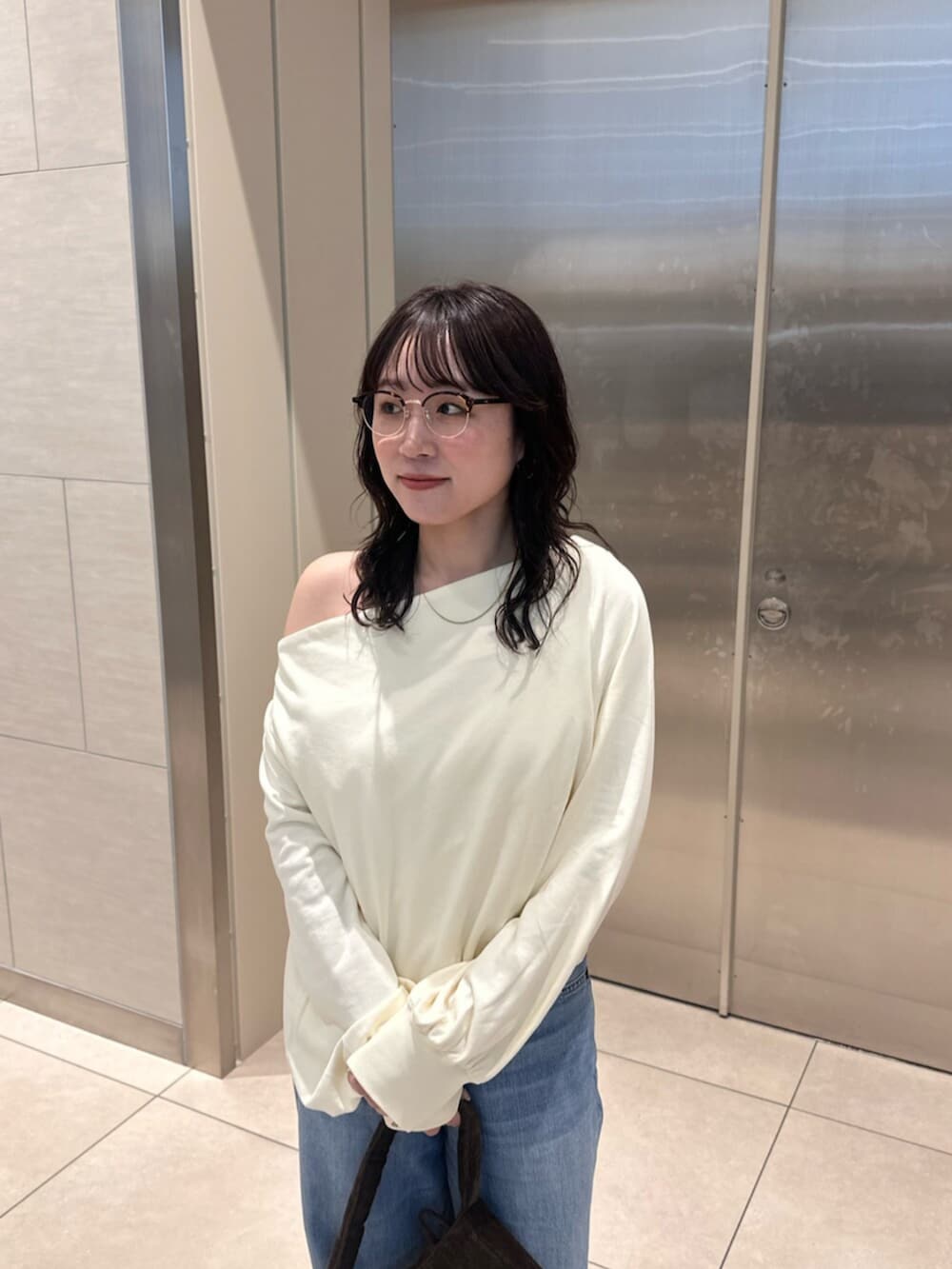 ホワイト系のTシャツ/カットソー、ブルー系のデニムパンツを着用したレディースの冬コーディネートの4枚目の写真