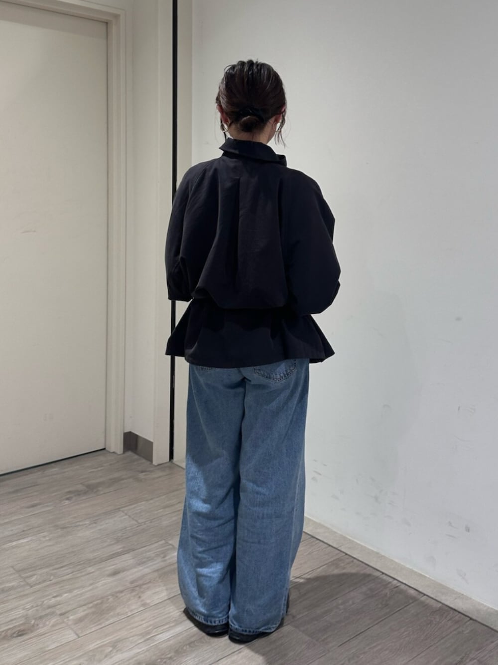 ブルー系のデニムパンツ、グレー系のトレンチコートを着用したレディースの秋コーディネートの4枚目の写真