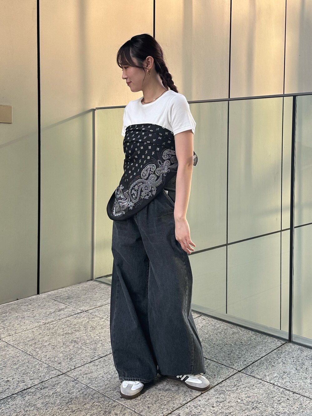 ホワイト系のTシャツ/カットソー、ブラック系のデニムパンツ、ブラック系のストール/ショールを着用したレディースの春コーディネートの2枚目の写真