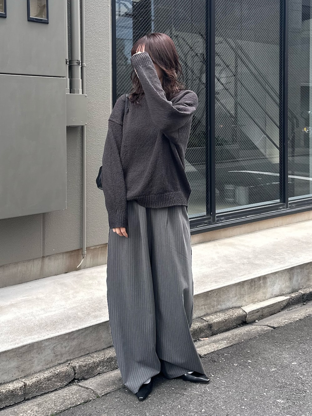 グレー系のニット/セーター、グレー系のその他パンツを着用したレディースの冬コーディネートの2枚目の写真