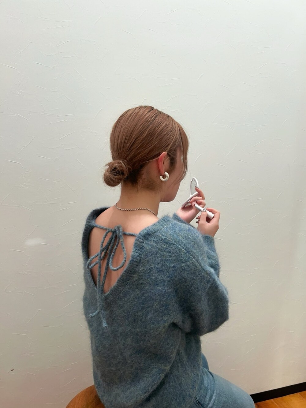 グリーン系のニット/セーター、ブルー系のデニムパンツを着用したレディースの冬コーディネートの2枚目の写真