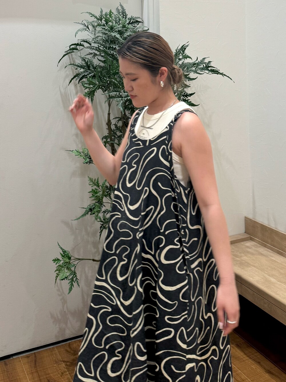 ホワイト系のタンクトップ、ブラック系のサンダル、ブルー系のデニムパンツを着用したレディースの夏コーディネートの5枚目の写真