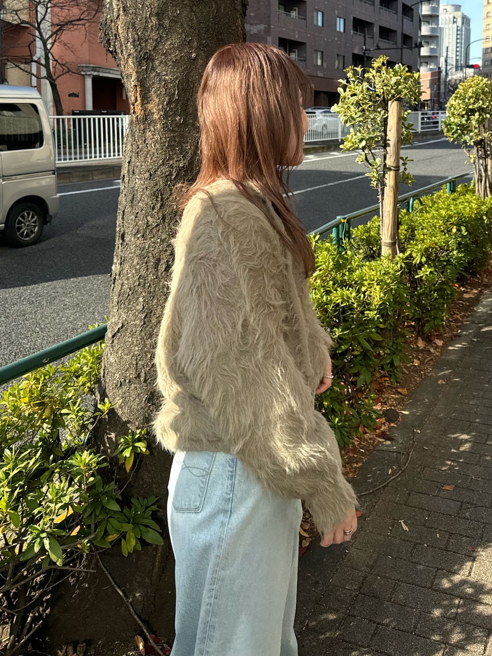 ブルー系のデニムパンツ、ブラウン系のニット/セーター、ホワイト系のTシャツ/カットソーを着用したレディースの冬コーディネートの5枚目の写真