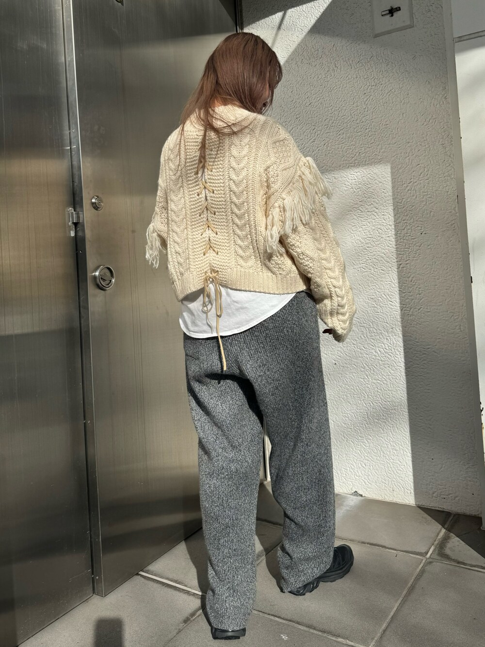 ホワイト系のニット/セーター、ホワイト系のTシャツ/カットソー、グレー系のその他パンツを着用したレディースの冬コーディネートの3枚目の写真