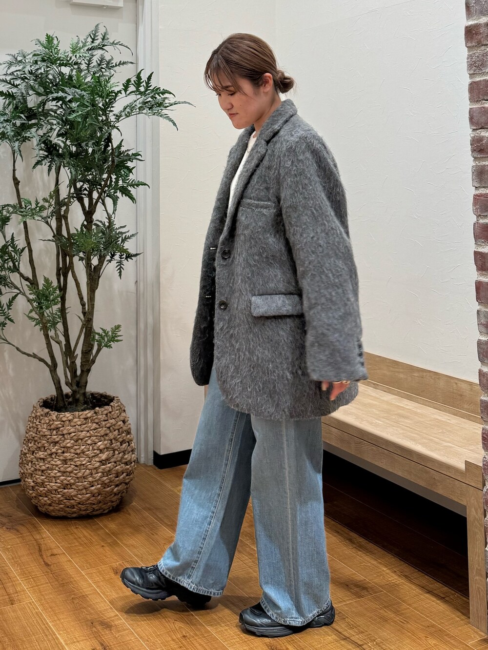 グレー系のテーラードジャケット、ブルー系のデニムパンツ、ホワイト系のニット/セーターを着用したレディースの秋コーディネートの2枚目の写真