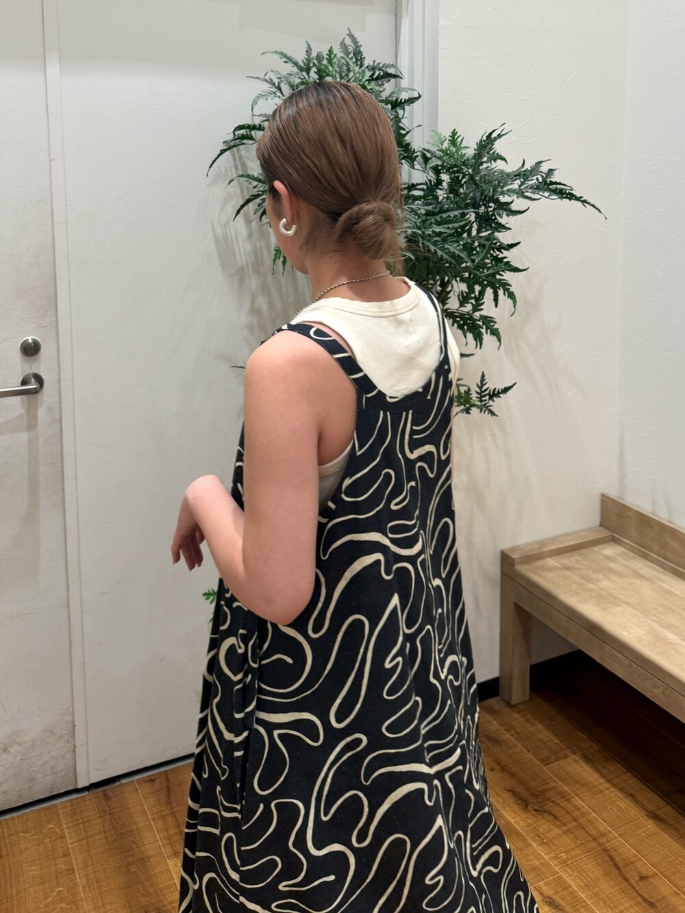 ホワイト系のタンクトップ、ブラック系のサンダル、ブルー系のデニムパンツを着用したレディースの夏コーディネートの6枚目の写真