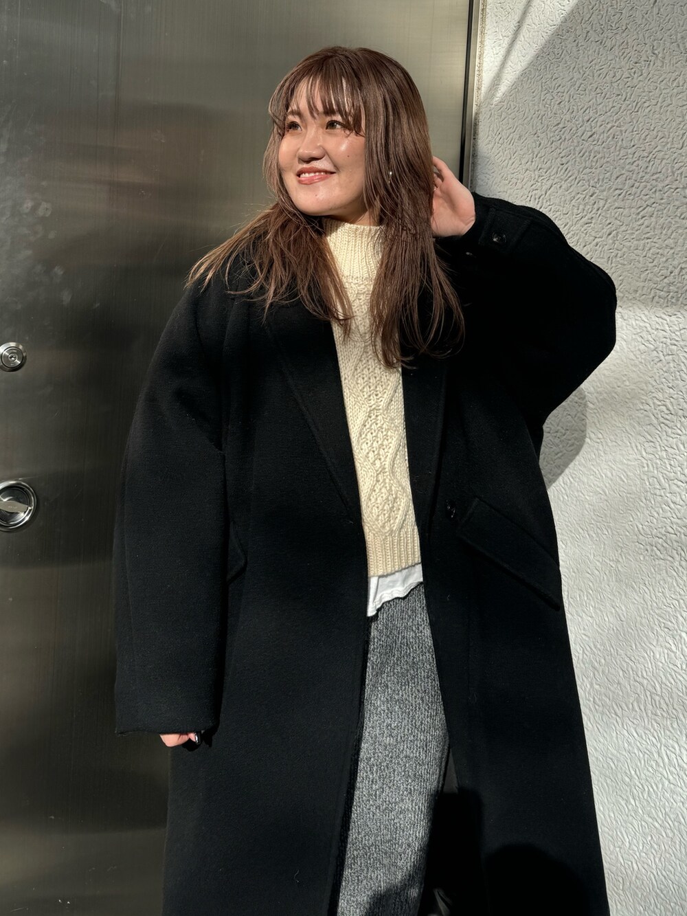 ホワイト系のニット/セーター、グレー系のその他パンツ、ブラック系のチェスターコートを着用したレディースの冬コーディネートの4枚目の写真