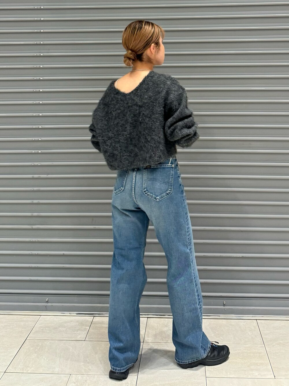 グレー系のニット/セーター、ブルー系のデニムパンツを着用したレディースの秋コーディネートの3枚目の写真