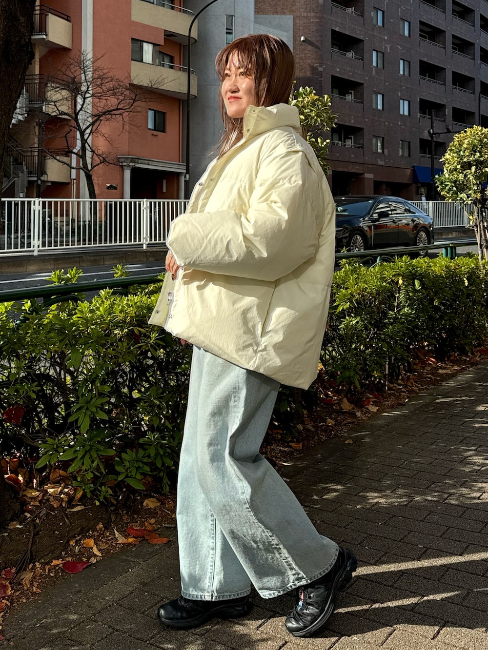 ブルー系のデニムパンツ、ホワイト系のダウンジャケット/コート、ベージュ系のニット/セーターを着用したレディースの冬コーディネートの3枚目の写真