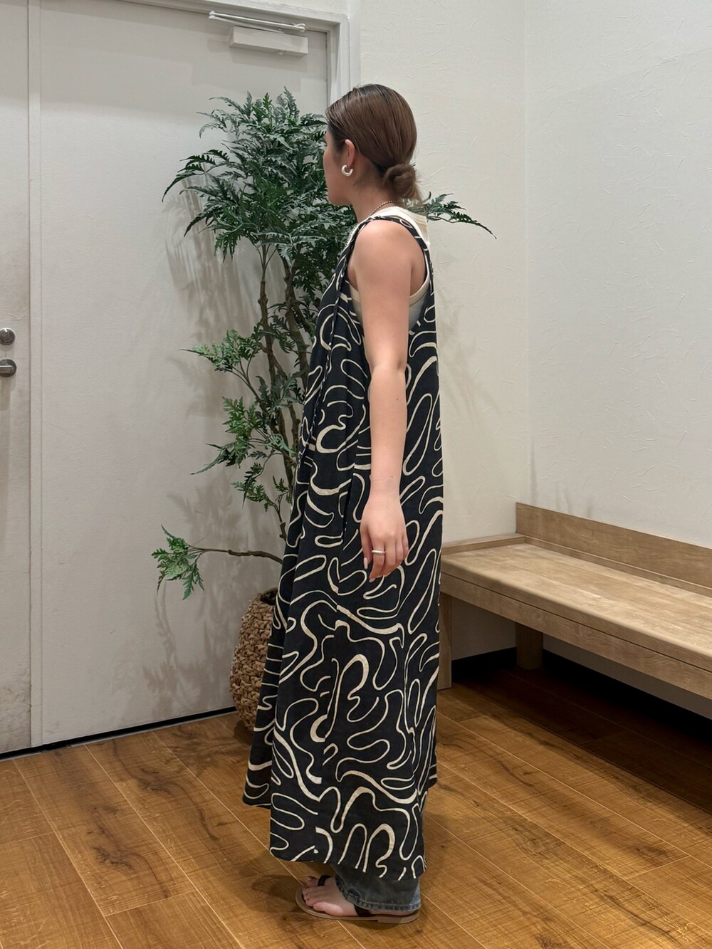 ホワイト系のタンクトップ、ブラック系のサンダル、ブルー系のデニムパンツを着用したレディースの夏コーディネートの3枚目の写真