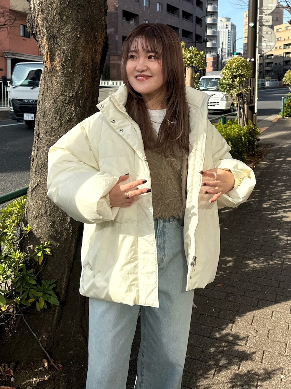 ブルー系のデニムパンツ、ホワイト系のダウンジャケット/コート、ベージュ系のニット/セーターを着用したレディースの冬コーディネートの5枚目の写真