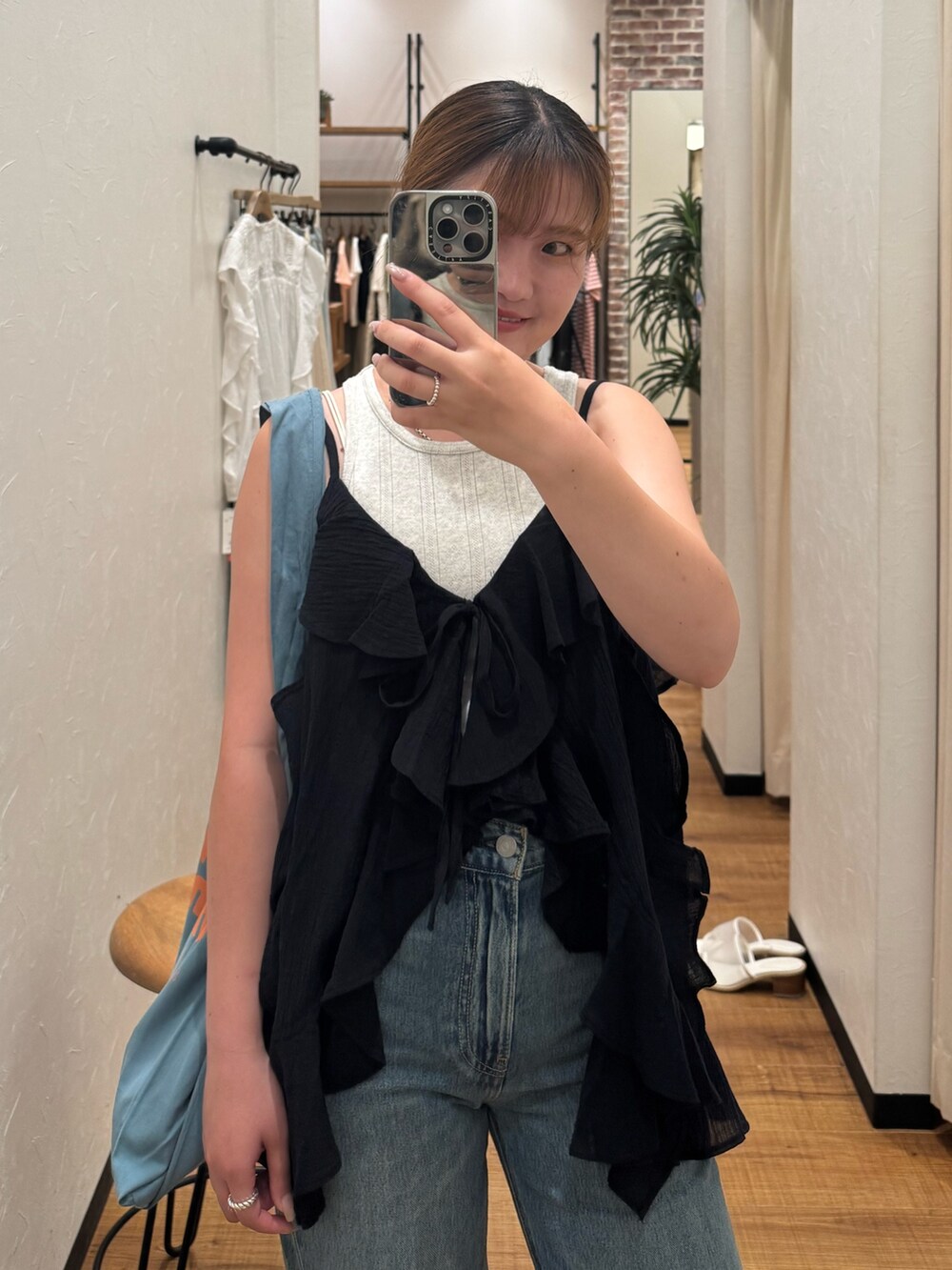 ブラック系のキャミソール、グレー系のタンクトップ、ブルー系のトートバッグを着用したレディースの夏コーディネートの4枚目の写真