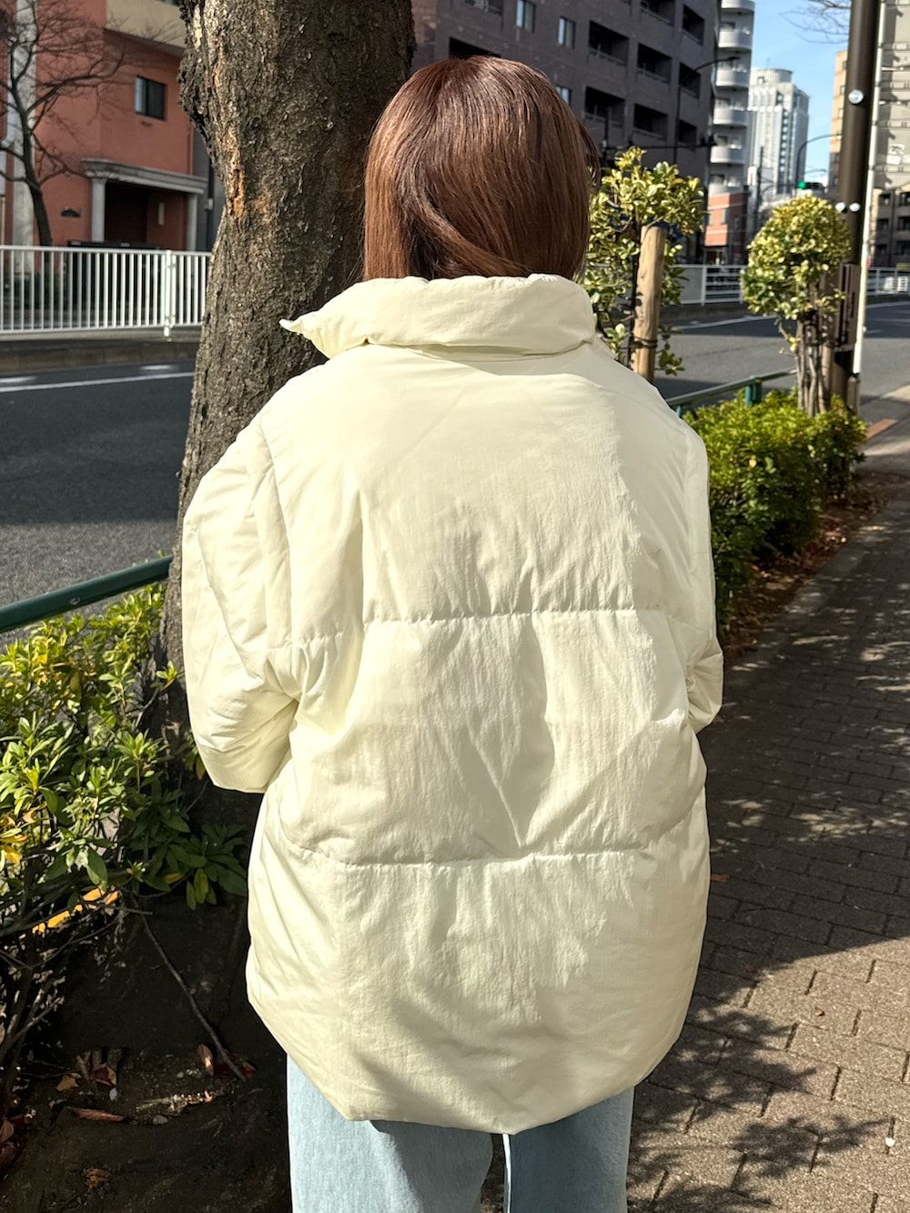 ブルー系のデニムパンツ、ホワイト系のダウンジャケット/コート、ベージュ系のニット/セーターを着用したレディースの冬コーディネートの7枚目の写真