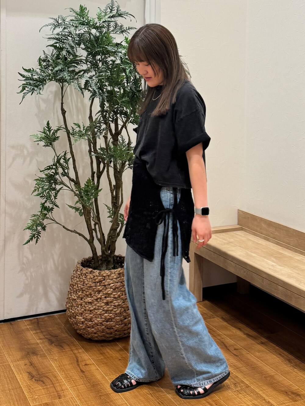 ブラック系のTシャツ/カットソー、ブラック系のスカート、ブルー系のデニムパンツを着用したレディースの春コーディネートの2枚目の写真