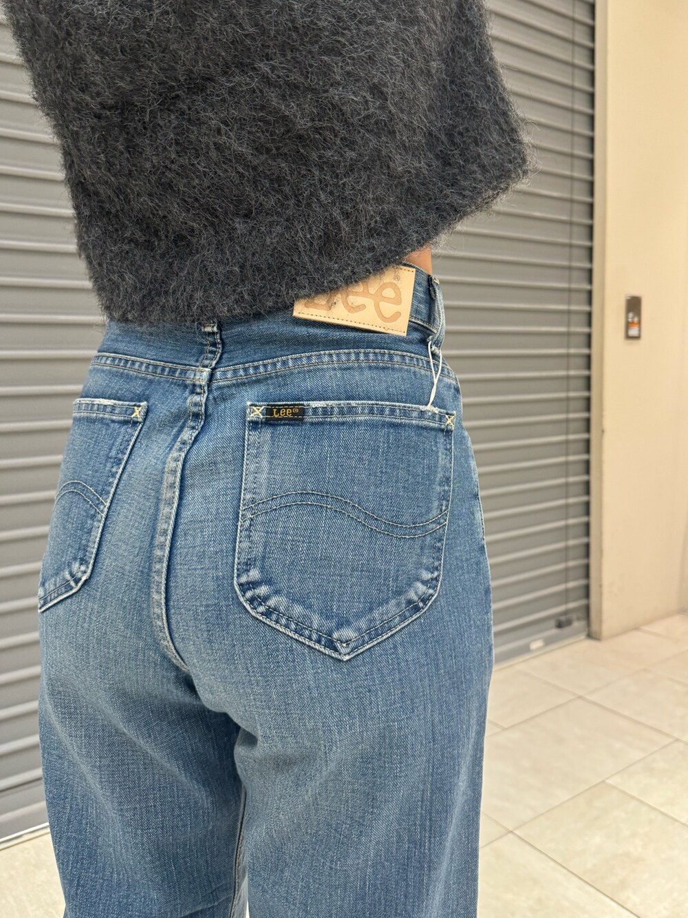 グレー系のニット/セーター、ブルー系のデニムパンツを着用したレディースの秋コーディネートの7枚目の写真