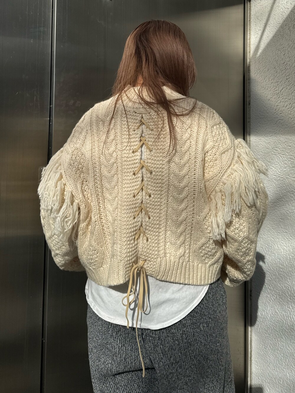 ホワイト系のニット/セーター、ホワイト系のTシャツ/カットソー、グレー系のその他パンツを着用したレディースの冬コーディネートの6枚目の写真