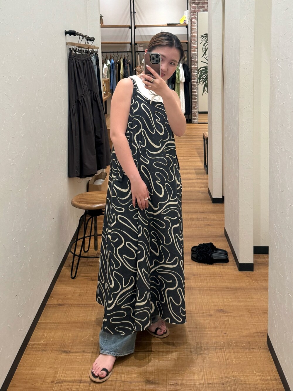 ホワイト系のタンクトップ、ブラック系のサンダル、ブルー系のデニムパンツを着用したレディースの夏コーディネートの7枚目の写真