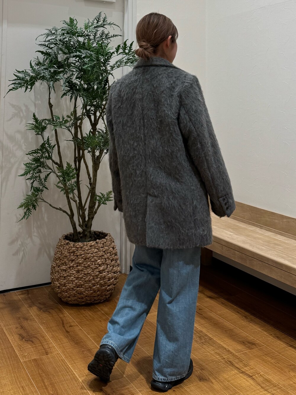 グレー系のテーラードジャケット、ブルー系のデニムパンツ、ホワイト系のニット/セーターを着用したレディースの秋コーディネートの3枚目の写真
