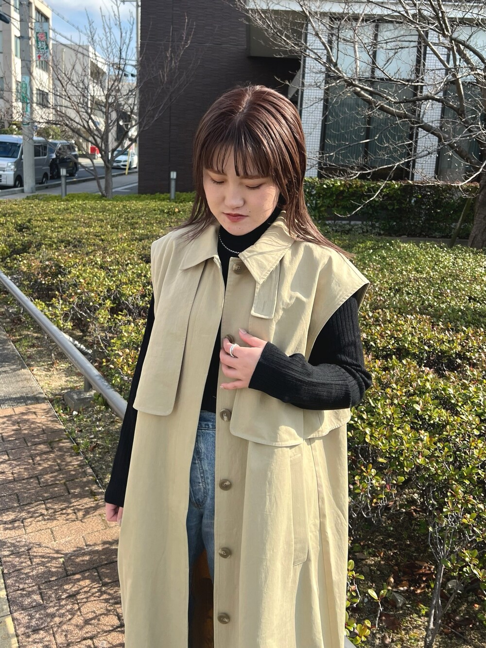 ブルー系のデニムパンツ、ブラック系のニット/セーター、ベージュ系のその他アウターを着用したレディースの冬コーディネートの2枚目の写真