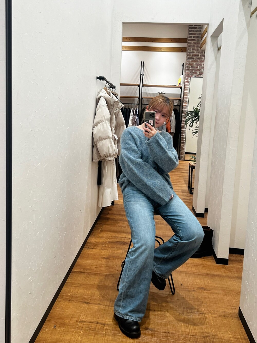 グリーン系のニット/セーター、ブルー系のデニムパンツを着用したレディースの冬コーディネートの4枚目の写真