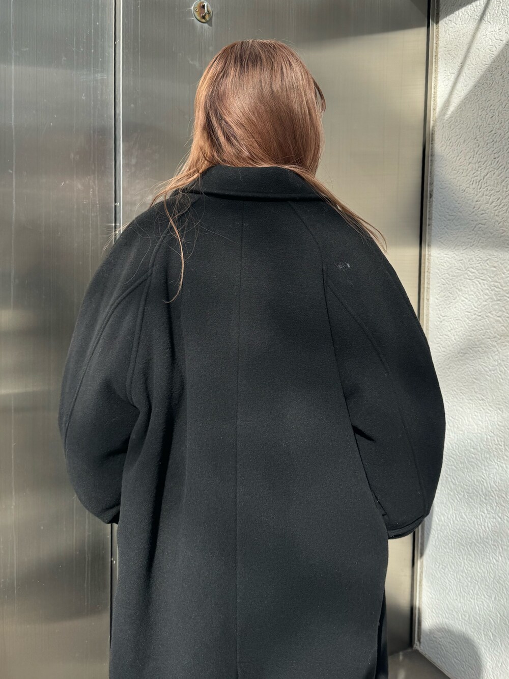 ホワイト系のニット/セーター、グレー系のその他パンツ、ブラック系のチェスターコートを着用したレディースの冬コーディネートの6枚目の写真