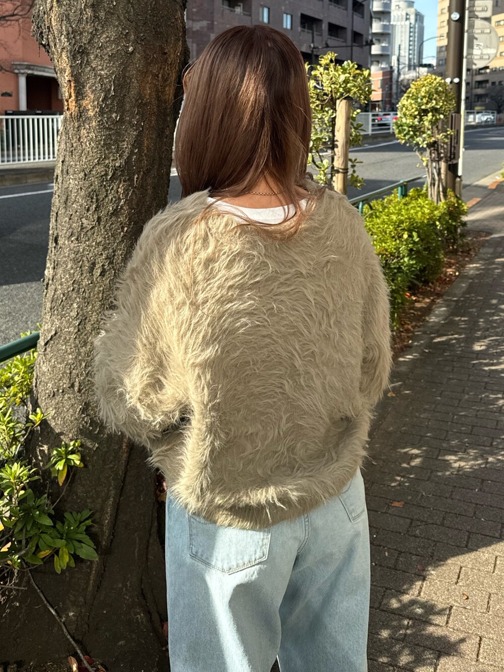 ブルー系のデニムパンツ、ブラウン系のニット/セーター、ホワイト系のTシャツ/カットソーを着用したレディースの冬コーディネートの6枚目の写真