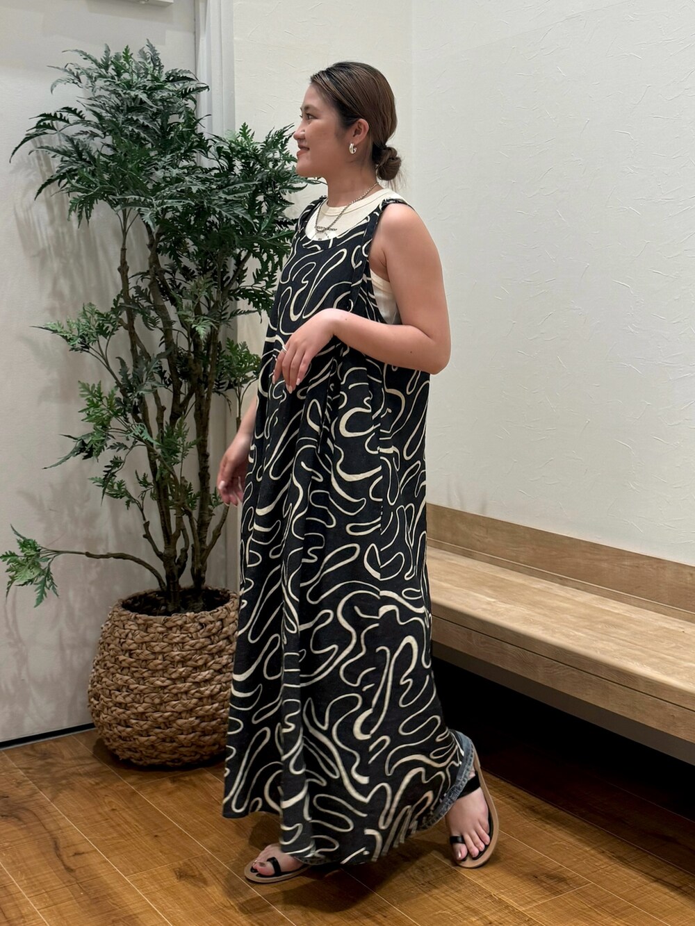 ホワイト系のタンクトップ、ブラック系のサンダル、ブルー系のデニムパンツを着用したレディースの夏コーディネートの2枚目の写真