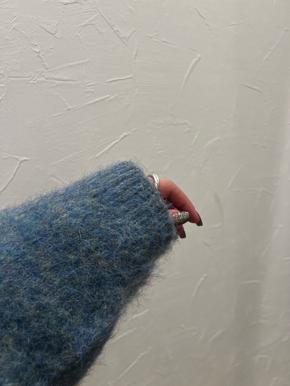 グリーン系のニット/セーター、ブルー系のデニムパンツを着用したレディースの冬コーディネートの3枚目の写真