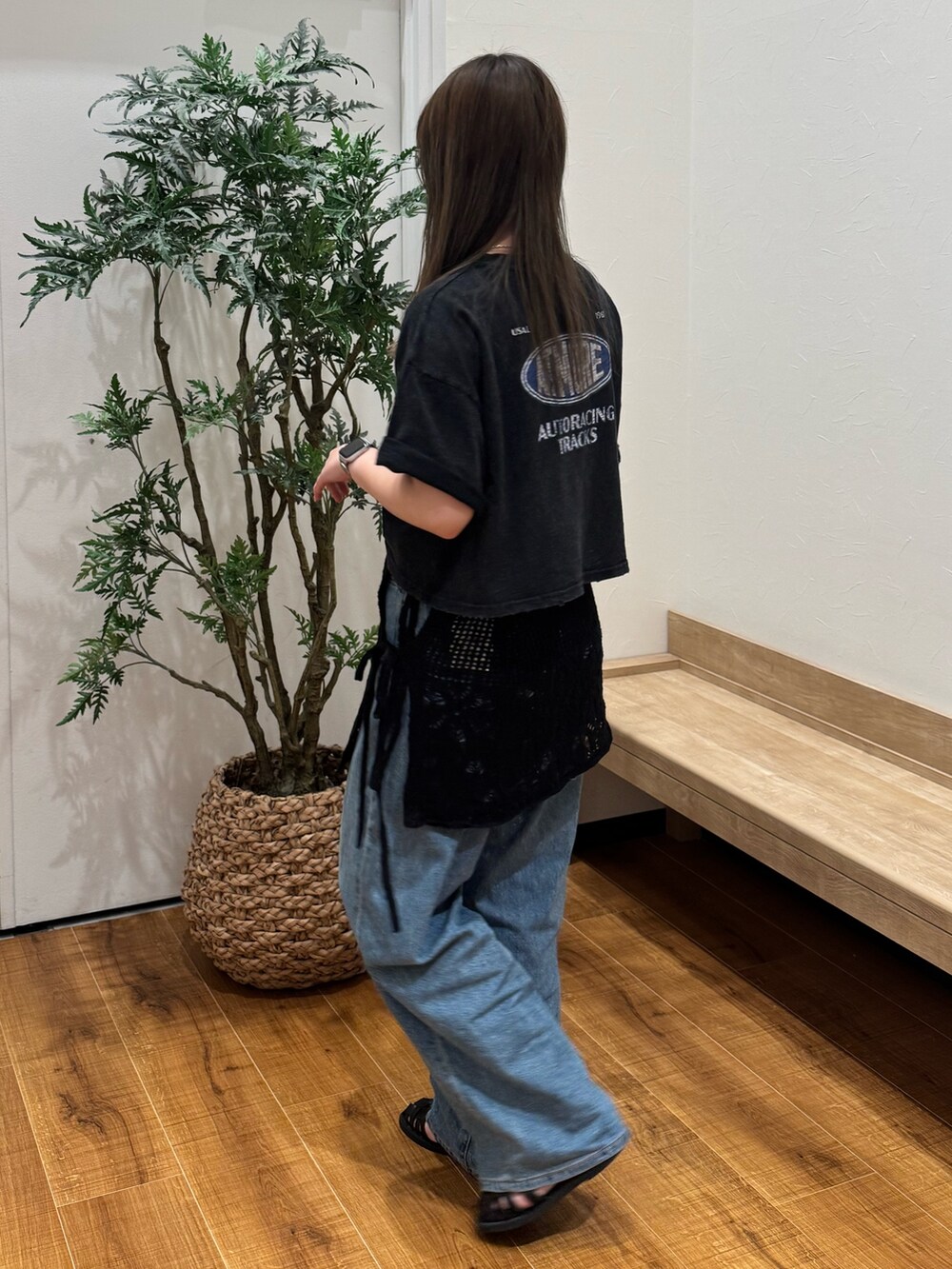 ブラック系のTシャツ/カットソー、ブラック系のスカート、ブルー系のデニムパンツを着用したレディースの春コーディネートの3枚目の写真