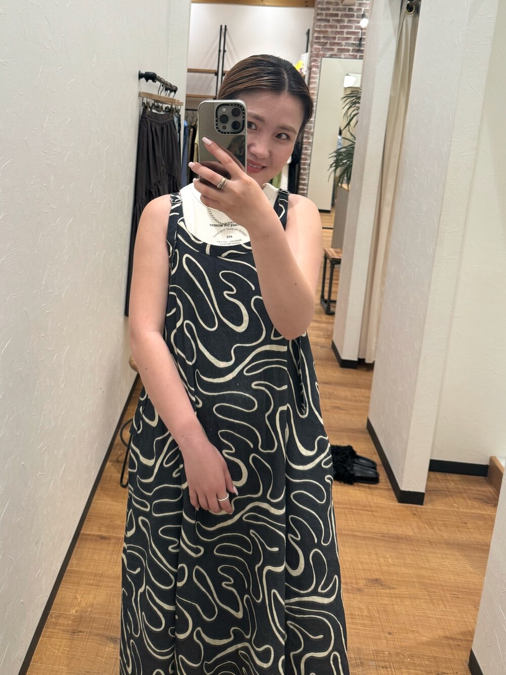 ホワイト系のタンクトップ、ブラック系のサンダル、ブルー系のデニムパンツを着用したレディースの夏コーディネートの8枚目の写真