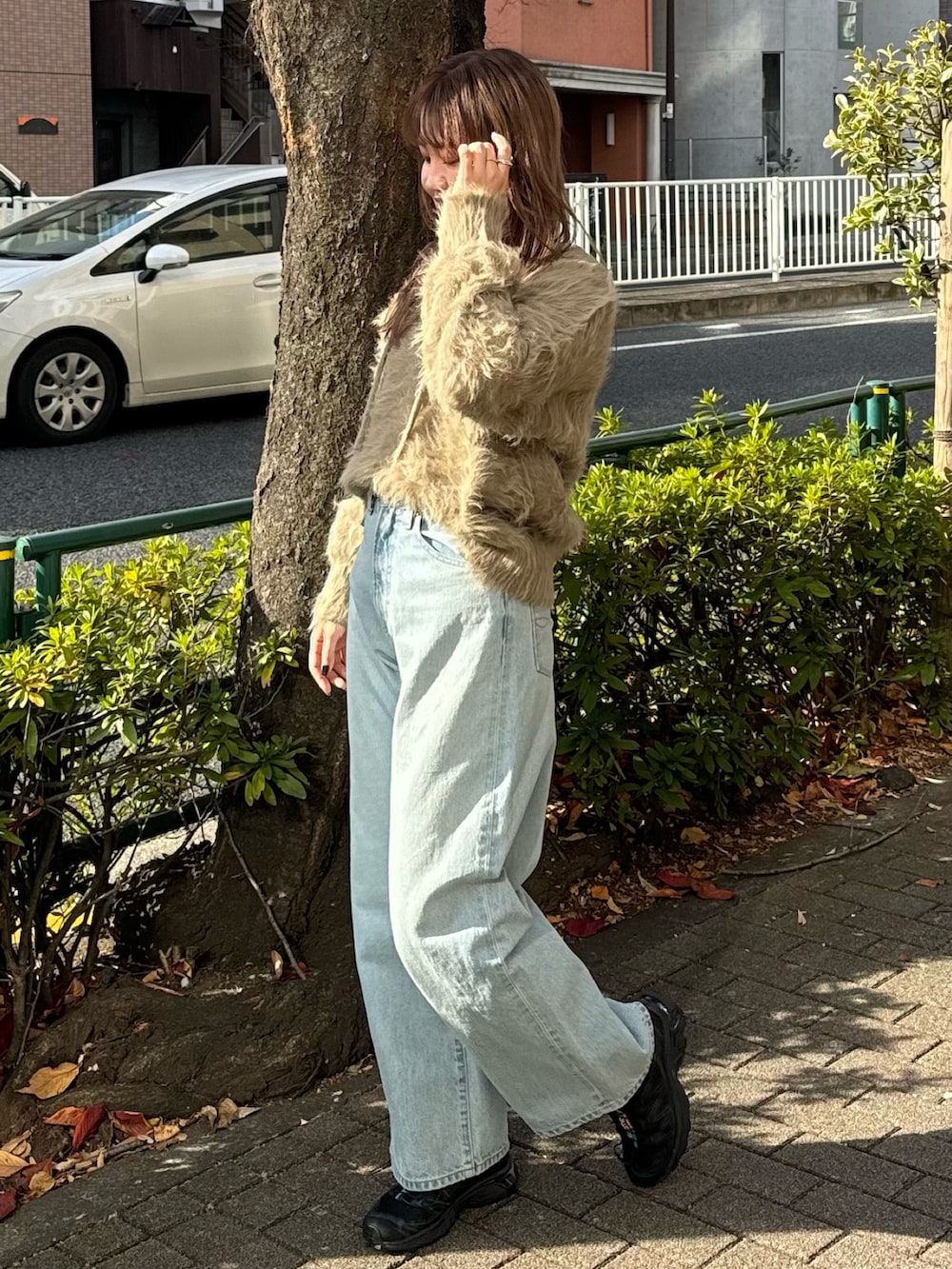 ブルー系のデニムパンツ、ブラウン系のニット/セーター、ホワイト系のTシャツ/カットソーを着用したレディースの冬コーディネートの2枚目の写真