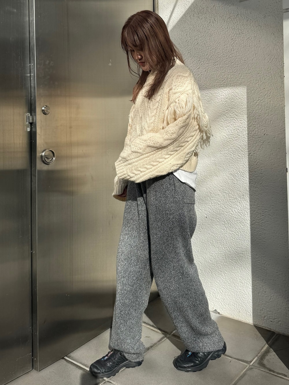 ホワイト系のニット/セーター、ホワイト系のTシャツ/カットソー、グレー系のその他パンツを着用したレディースの冬コーディネートの2枚目の写真