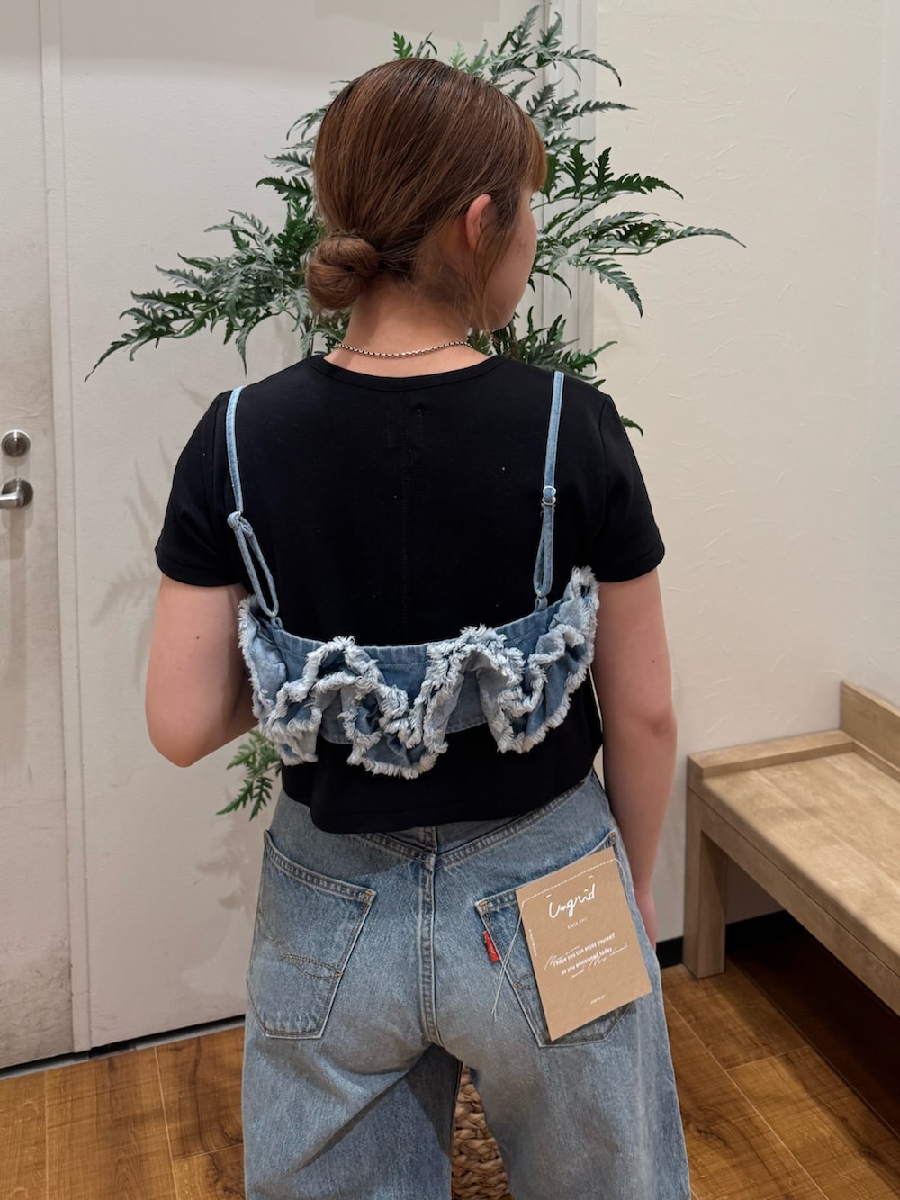 ブラック系のTシャツ/カットソー、ブルー系のキャミソール、ブルー系のデニムパンツを着用したレディースの春コーディネートの6枚目の写真