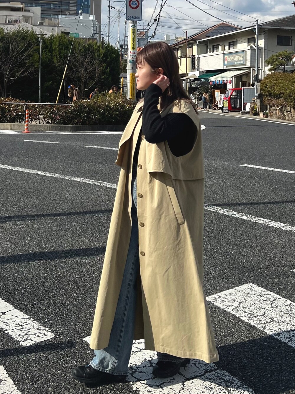 ブルー系のデニムパンツ、ブラック系のニット/セーター、ベージュ系のその他アウターを着用したレディースの冬コーディネートの5枚目の写真