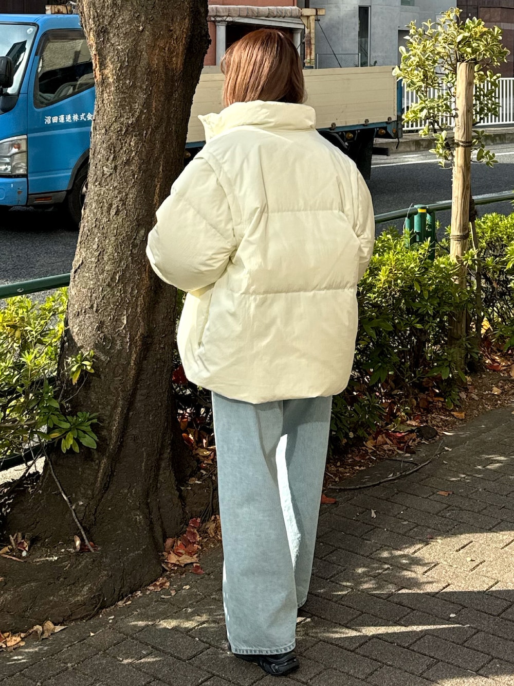 ブルー系のデニムパンツ、ホワイト系のダウンジャケット/コート、ベージュ系のニット/セーターを着用したレディースの冬コーディネートの4枚目の写真