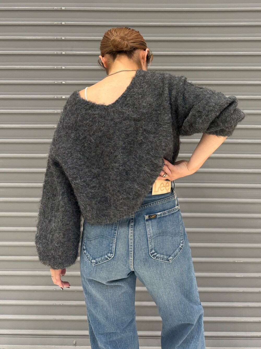 グレー系のニット/セーター、ブルー系のデニムパンツを着用したレディースの秋コーディネートの6枚目の写真