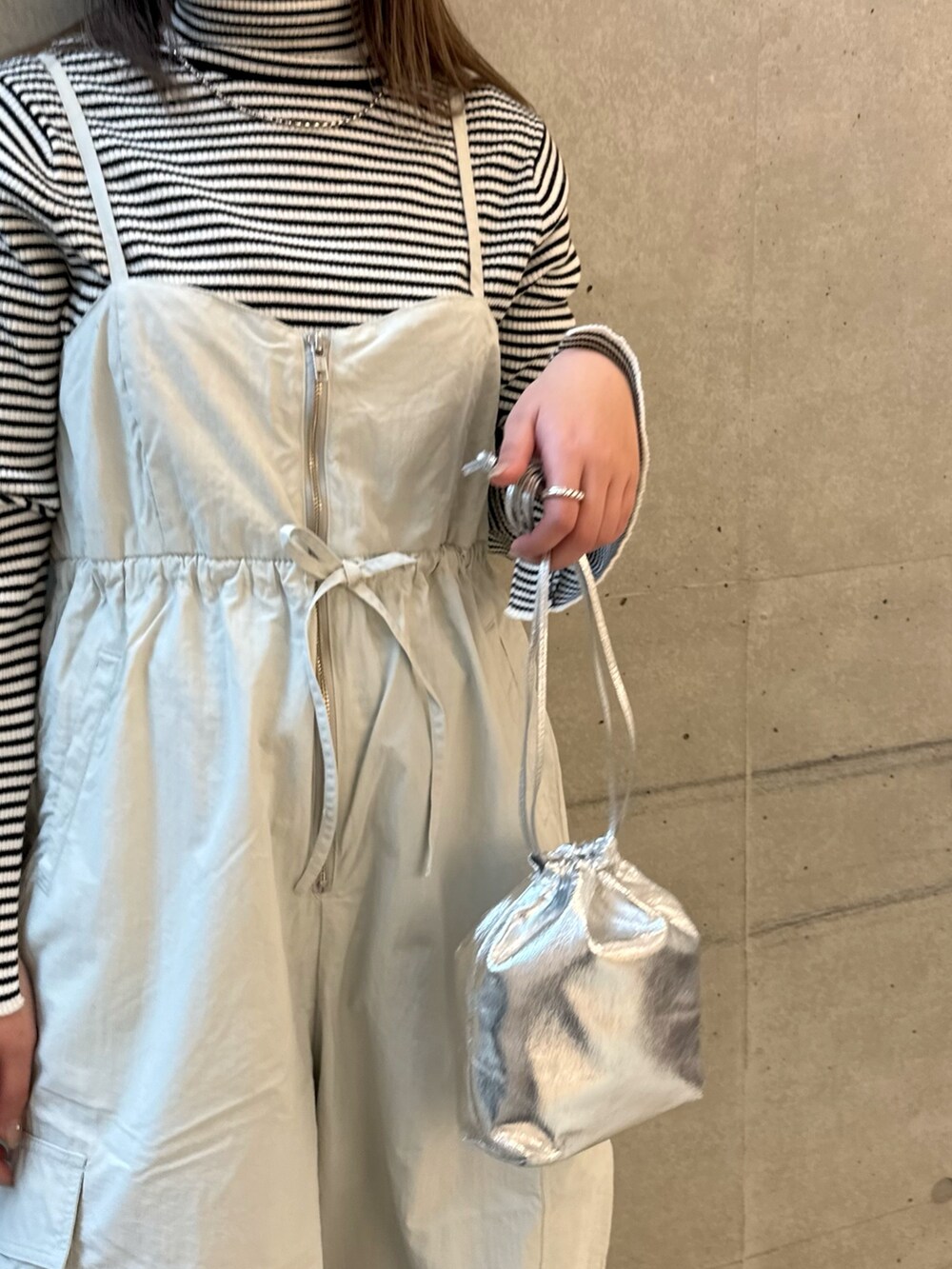 ホワイト系のニット/セーター、グレー系のサロペット/オーバーオール、ブラック系のパンプスを着用したレディースの冬コーディネートの4枚目の写真