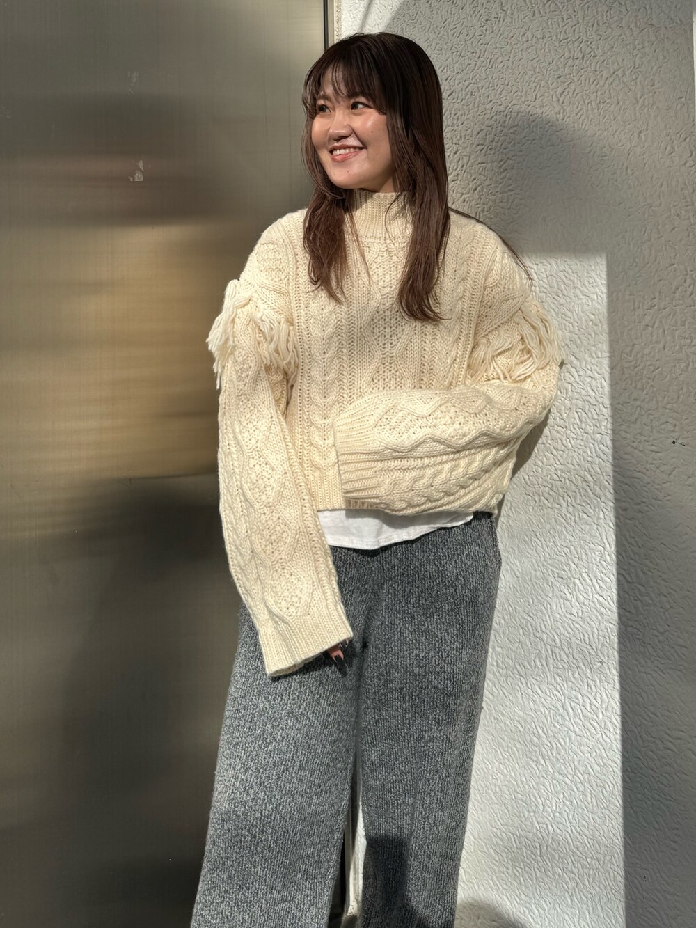 ホワイト系のニット/セーター、ホワイト系のTシャツ/カットソー、グレー系のその他パンツを着用したレディースの冬コーディネートの4枚目の写真