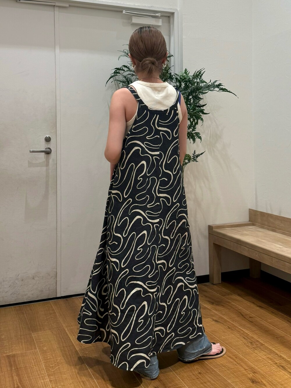 ホワイト系のタンクトップ、ブラック系のサンダル、ブルー系のデニムパンツを着用したレディースの夏コーディネートの4枚目の写真