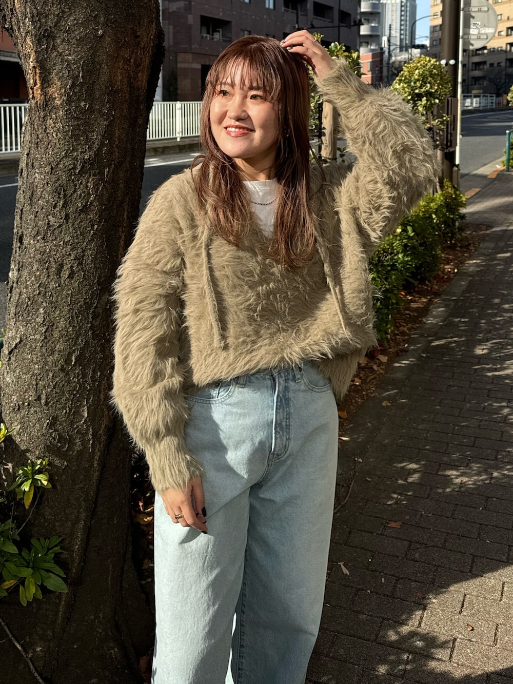 ブルー系のデニムパンツ、ブラウン系のニット/セーター、ホワイト系のTシャツ/カットソーを着用したレディースの冬コーディネートの4枚目の写真