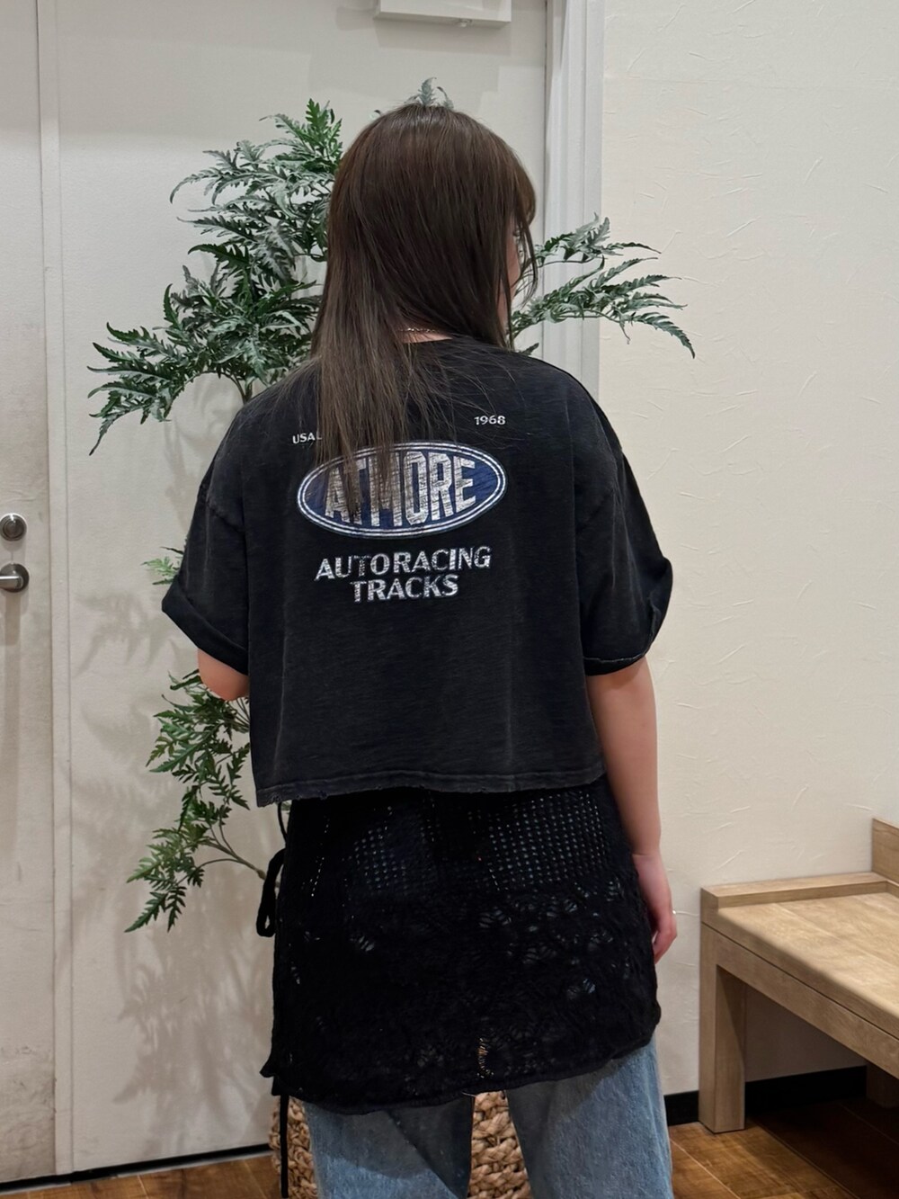 ブラック系のTシャツ/カットソー、ブラック系のスカート、ブルー系のデニムパンツを着用したレディースの春コーディネートの6枚目の写真