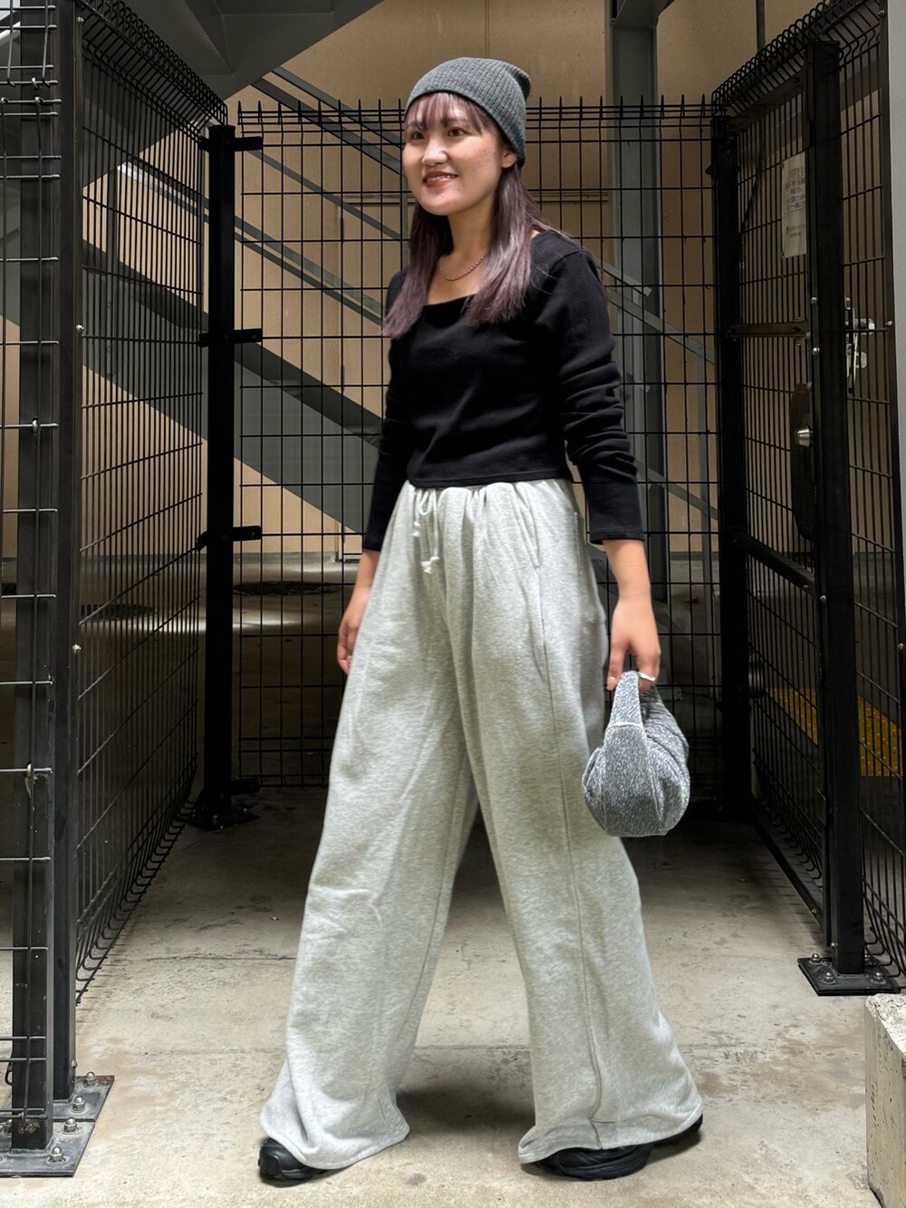 ブラック系のTシャツ/カットソー、グレー系のスウェットパンツ、ブラック系のハンドバッグを着用したレディースの秋コーディネートの2枚目の写真