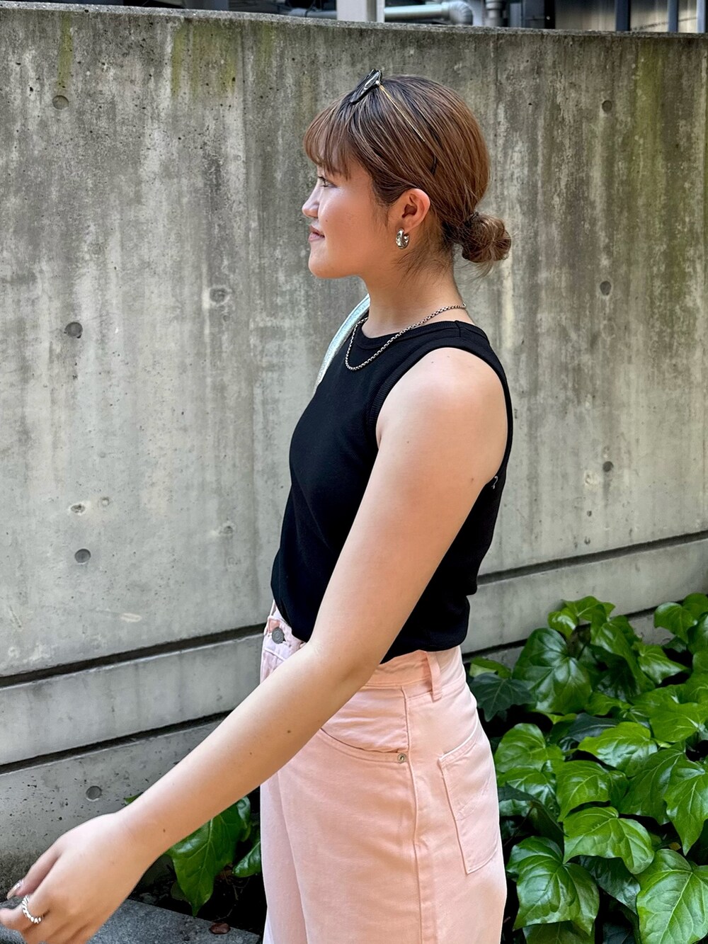 ブラック系のタンクトップ、ピンク系のデニムパンツ、シルバー系のハンドバッグを着用したレディースの春コーディネートの7枚目の写真