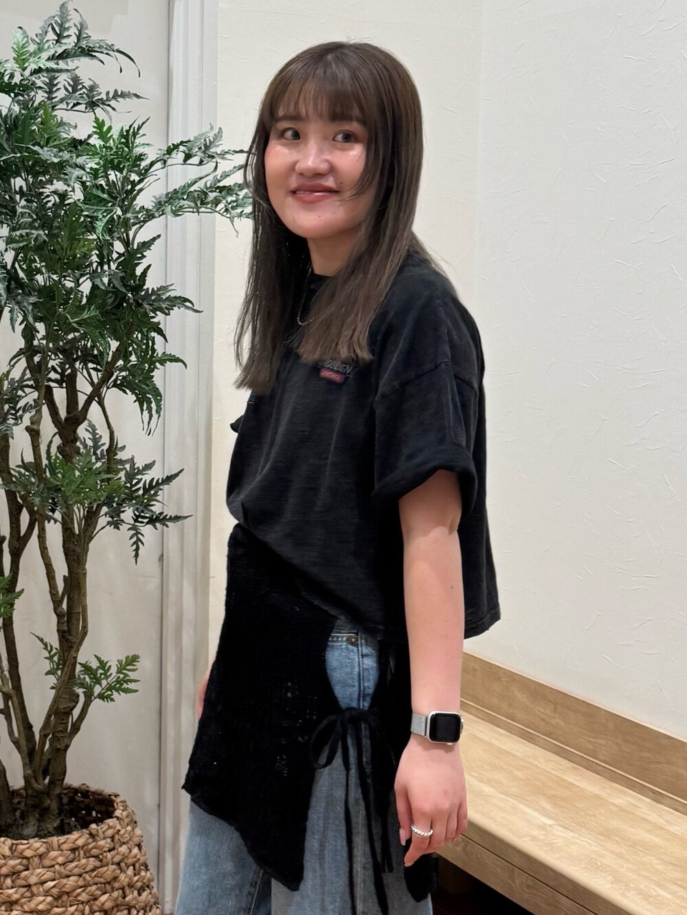 ブラック系のTシャツ/カットソー、ブラック系のスカート、ブルー系のデニムパンツを着用したレディースの春コーディネートの5枚目の写真