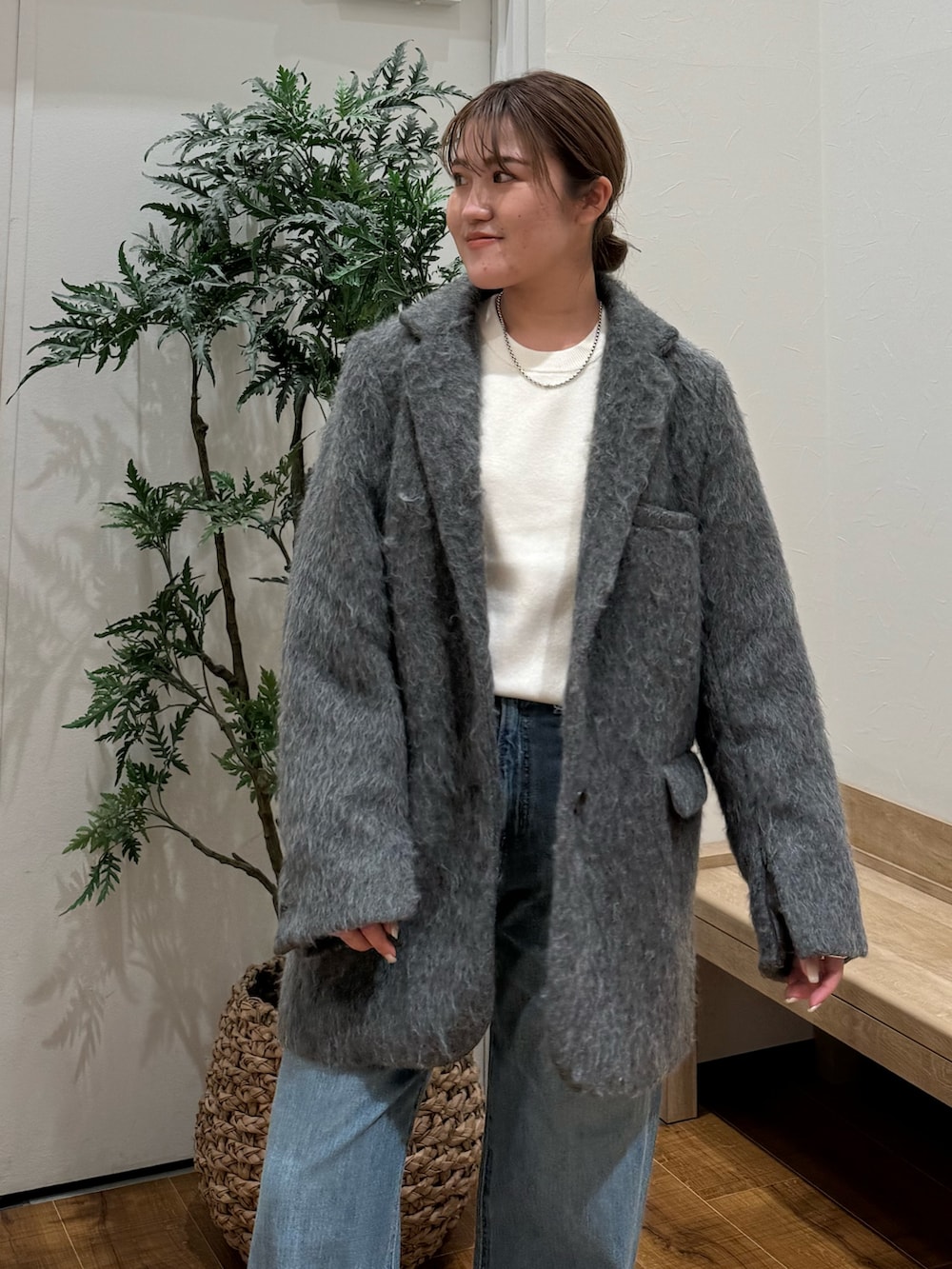グレー系のテーラードジャケット、ブルー系のデニムパンツ、ホワイト系のニット/セーターを着用したレディースの秋コーディネートの4枚目の写真