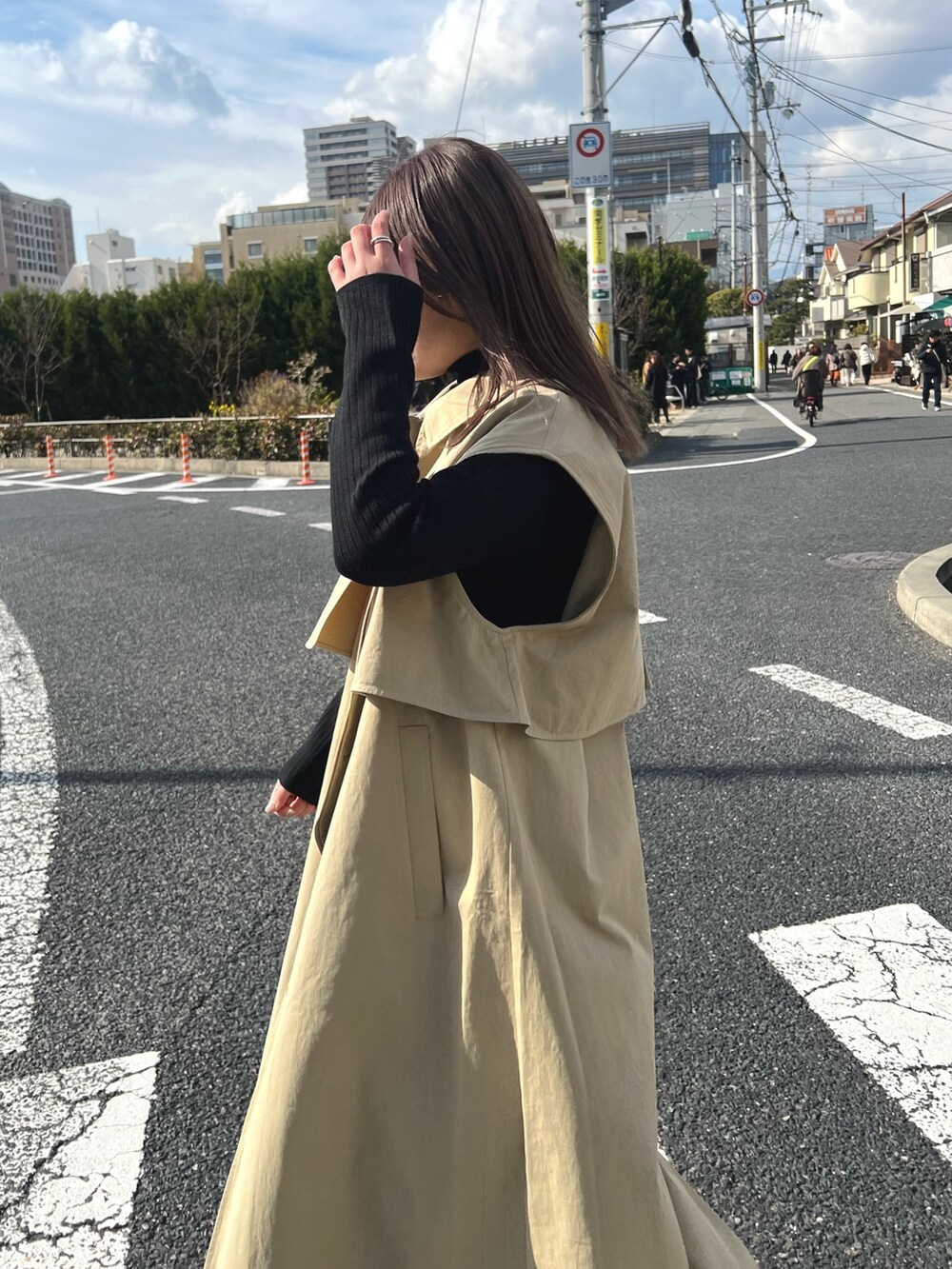 ブルー系のデニムパンツ、ブラック系のニット/セーター、ベージュ系のその他アウターを着用したレディースの冬コーディネートの4枚目の写真