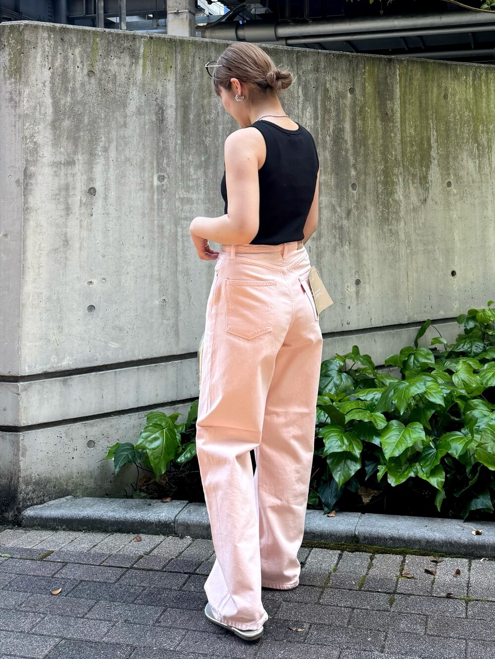 ブラック系のタンクトップ、ピンク系のデニムパンツ、シルバー系のハンドバッグを着用したレディースの春コーディネートの4枚目の写真