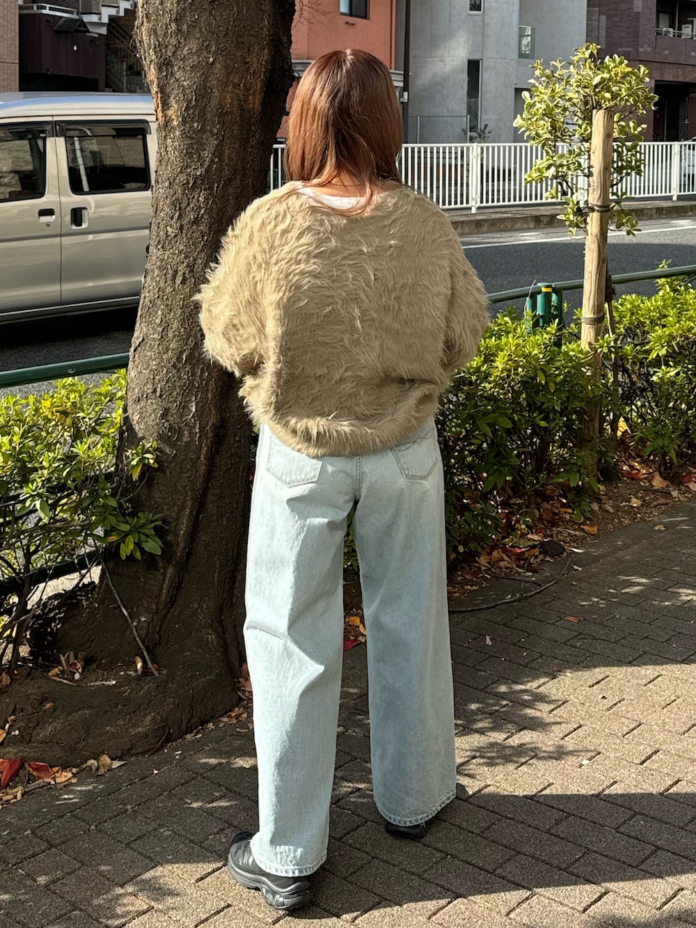 ブルー系のデニムパンツ、ブラウン系のニット/セーター、ホワイト系のTシャツ/カットソーを着用したレディースの冬コーディネートの3枚目の写真